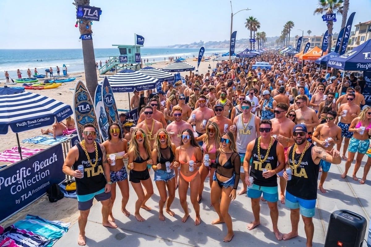 Large crowd of beachgoers in swimwear at a sunny beach event with blue tents, palm trees, and ocean in the background