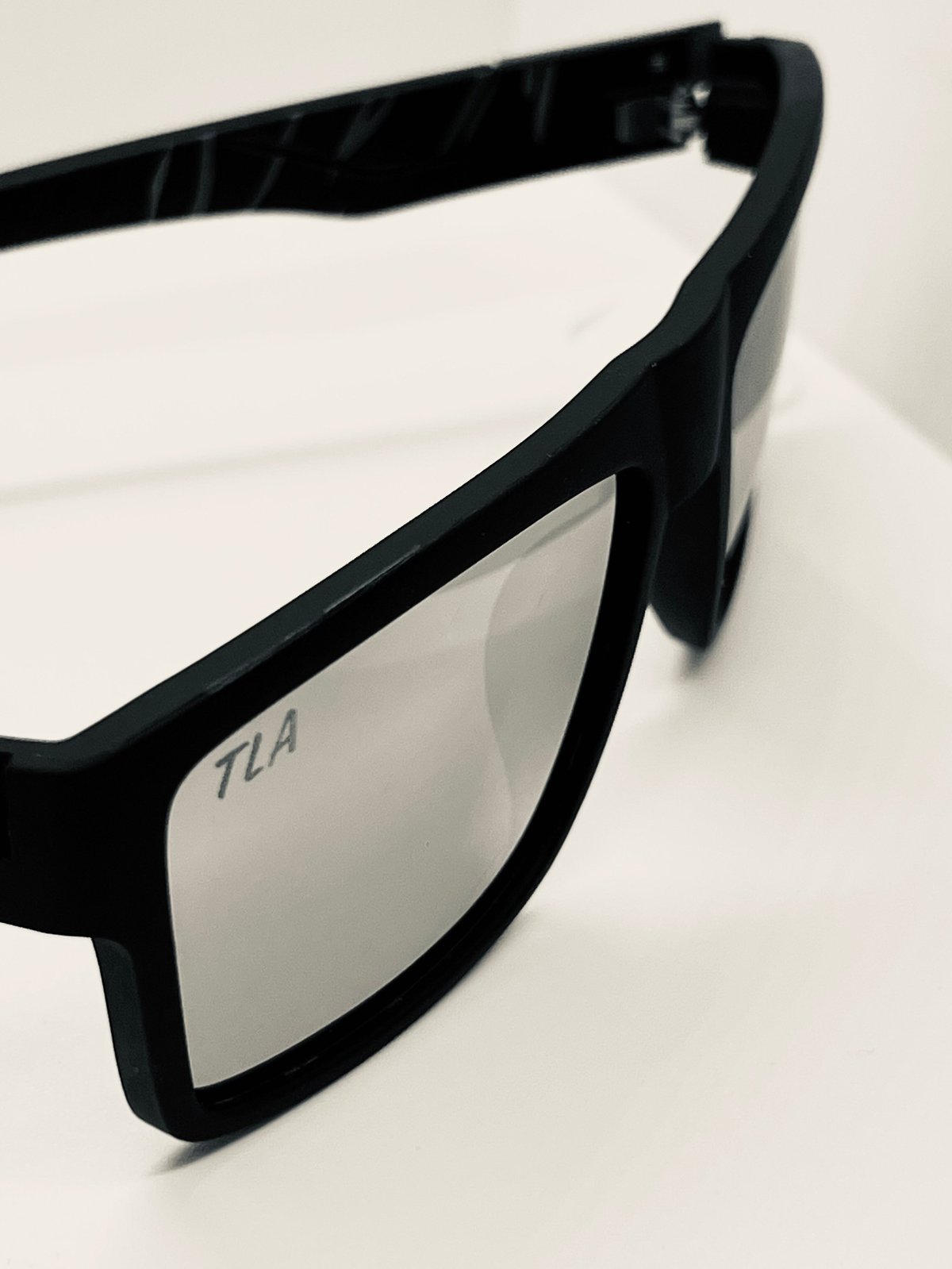 The OG Black Silver sunglasses with black frames and silver-tinted lens, the TLA logo etched on the light-tinted lens