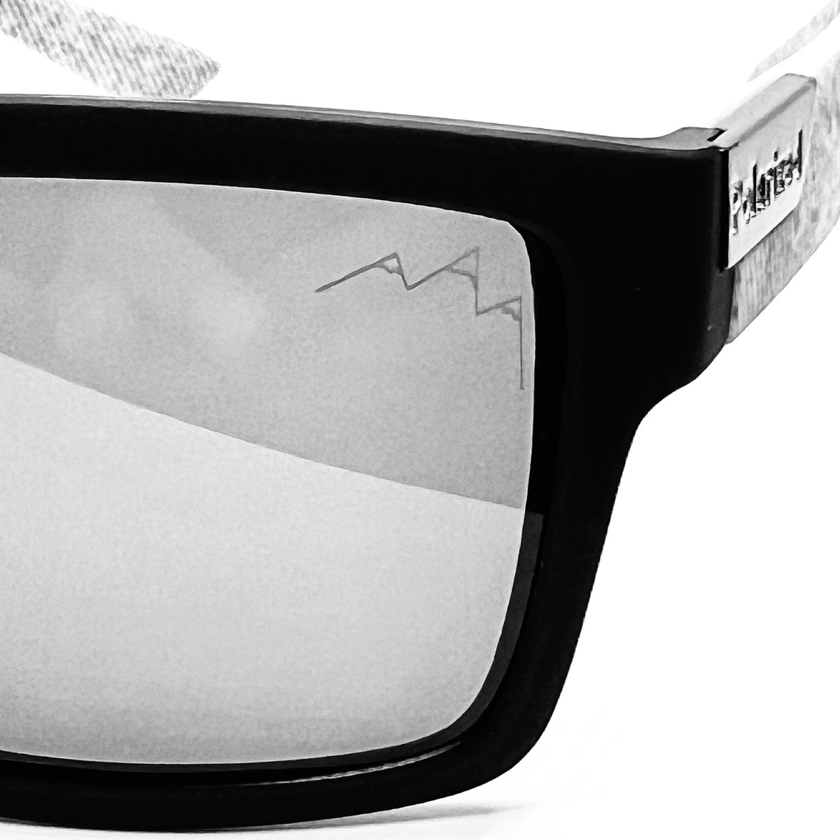 Black-framed sunglasses with white gradient lenses, the TLA mountain logo etched on the lens against a white background